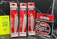 Front view of three Yo-Zuri 3DB Jerkbait lures and one Yo-Zuri Super Braid line in packaging