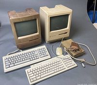 Two compact Macintosh computers, external floppy drive, keyboards, mouse and cables