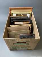 Cardboard box containing multiple frames of various sizes and finishes