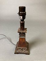 Full view of brown table lamp base with cord and socket, pedestal design