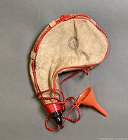 Front view of leather canteen with cord, cap and funnel