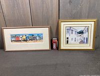 Both framed prints side by side with soda can for scale