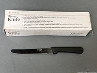 Box marked Browne Dinner Knife with one black-handled serrated knife displayed