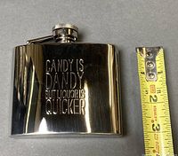 Flask front showing engraving and measuring tape indicating size