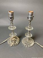 Pair of clear pressed glass table lamps showing full form and wiring