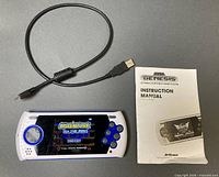 Console, charging cable, instruction manual displayed on surface