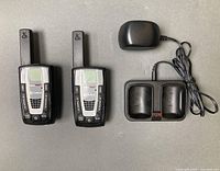 Front view of two radios, charging cradle and adapter