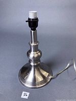 Front view of brushed silver metal table lamp base with cord