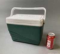 Front view of green Thermos cooler beside soda can for scale