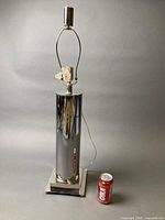 Full view of chrome cylinder lamp with coke can for scale