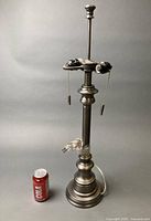 Full view of pewter finish lamp beside soda can for scale