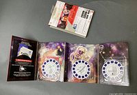 Tri-fold booklet opened with three space reels and rear of box