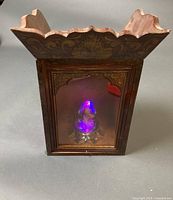 Full view of wooden display case with egg lit inside