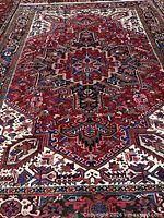 Full view of red-field Heriz rug showing central medallion and borders