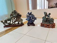Overview of three soapstone sculptures on stands