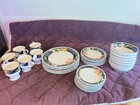Set of plates, bowls and mugs arranged on surface