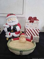 Front view of Santa cookie jar, three gift box containers, and Santa rim dish