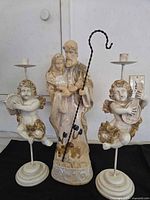 Front view of nativity figurine with two cherub candle holders