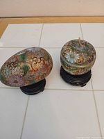 Egg box and round covered jar on wood stands