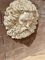 Front view of cast stone plaque showing bearded male relief