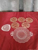 Group shot of serving plate, triangular dish and six floral saucers