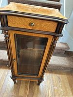 Full front view of curio cabinet showing drawer, glass door and shelves