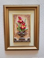 Full view of framed floral relief plaque hanging on wall