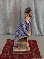 Full view of clown figurine on wood base