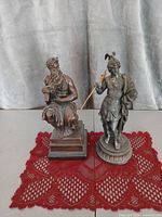 Both figurines side by side showing relative scale and patina