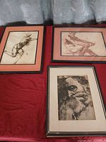 All three framed classical male nude prints displayed on table