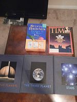 Group shot of three Voyage Through the Universe hardcovers, one Time magazine and Sylvia Browne box visible