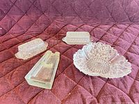 Group view of all pressed glass pieces on quilted background