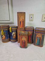 Group shot of seven angel and floral decorative tins