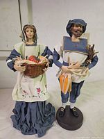 Front view of both figurines showing attire, accessories, and overall condition