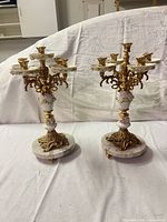 Full view of both matching five-arm candelabra on marble bases