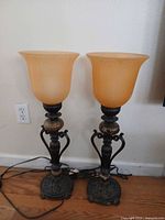 Pair of table lamps showing full height, bases, marble accents, amber glass shades