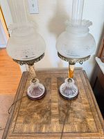 Pair of matching hurricane lamps showing full structure and attached cords