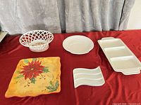 Overview of five porcelain serveware pieces on red surface
