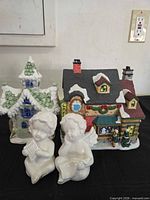 Front view of two village houses and two angel figurines