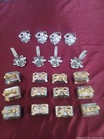 All sixteen napkin rings grouped by design on red cloth