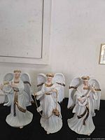 Front view of all three angels displaying instruments and gold accents