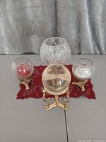 Front view of all four candle holders showing globes and brass bases