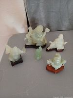 Group shot of all five jade carvings on surface