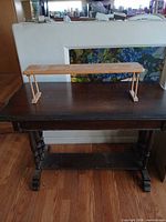 Full view of bench on tabletop showing size, finish and leg style