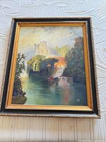 Front view of framed Stan Riley oil painting depicting castle landscape