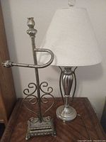 Table lamp and decorative metal stand on wooden surface
