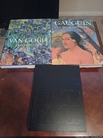 Two art books and black slipcase on table