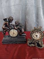 Front view of both tabletop clocks: Crosa cherub clock and ornate scroll clock