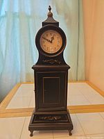 Full view of black wood clock cabinet front