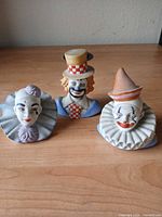 All three ceramic clown bust figurines on tabletop